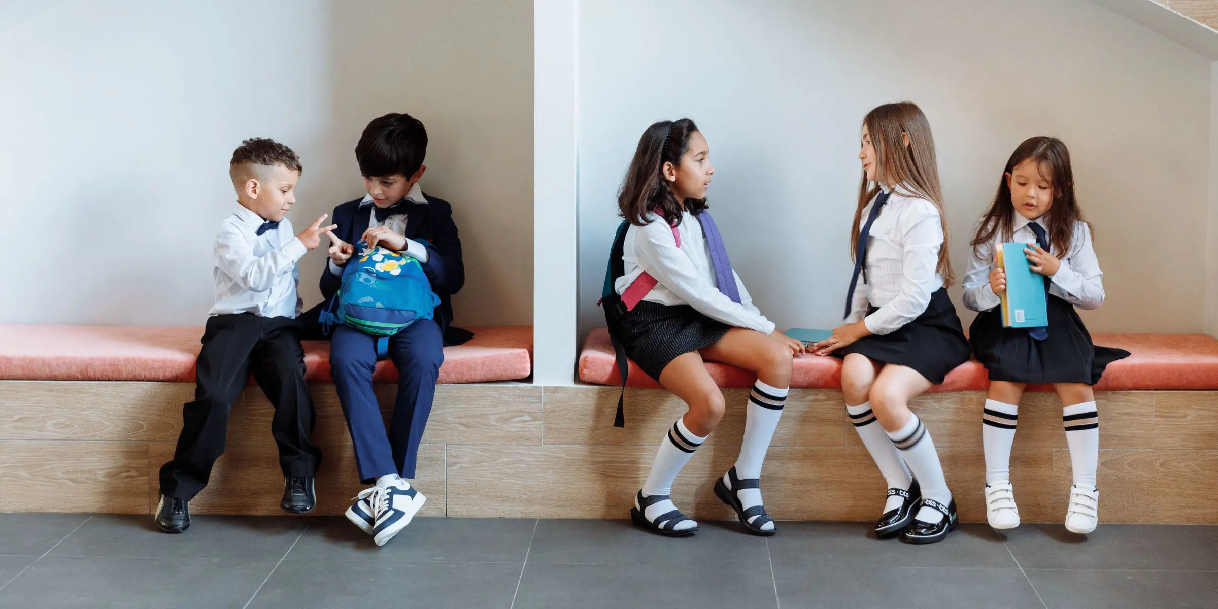 Younger grade pupils talking in hall during break time - amplify marketing for schools banner image 1