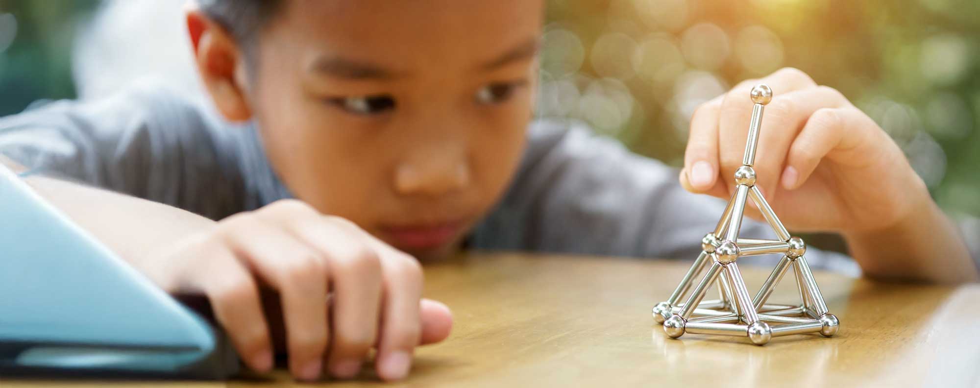 Amplify - banner for inbound marketing for private scools - boy playing with magnets
