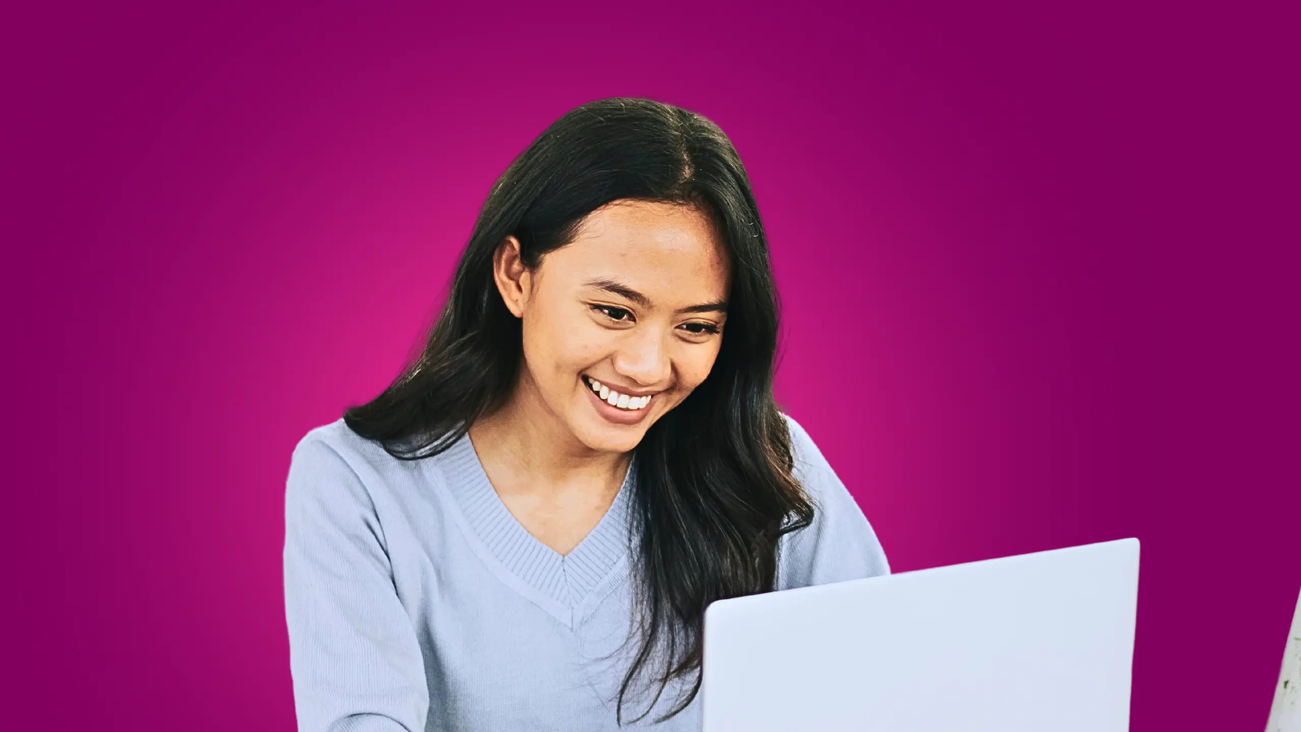 A millennial woman holds her laptop looking proud of her insights