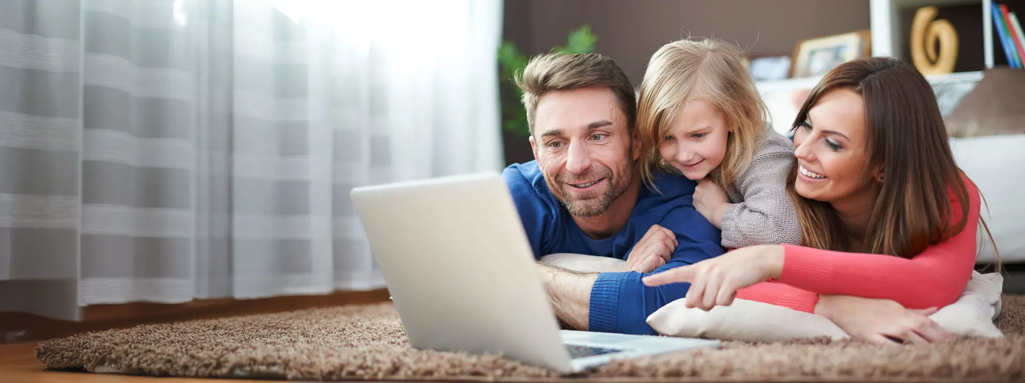 best school websites 2025 family looking for schools on laptop on the floor of living room